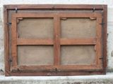 an old window with a wooden frame on the outside of it