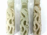 three jade carved vases sitting next to each other on a white surface