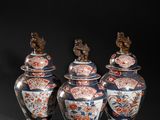 three vases with lids and a bird on top of them