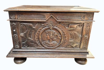 un coffre en bois sculpté, monté sur roulettes