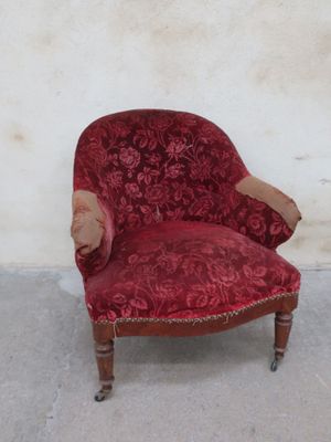 a red chair that is sitting against a white wall