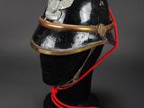 an old helmet with a red cord attached to it on a mannequin head