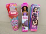 two barbie dolls are sitting next to each other on a table