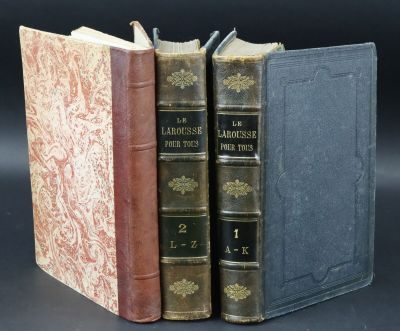 three books are stacked on top of each other on a black surface