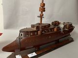 a wooden model of a ship on a white surface
