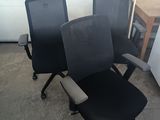 trois chaises de bureau noires placées les unes à côté des autres dans une pièce