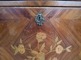 a wooden chest of drawers with a floral design on it