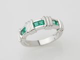 a white gold ring set with emerald stones