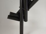 une sculpture noire composée de tubes métalliques, posée sur un socle noir