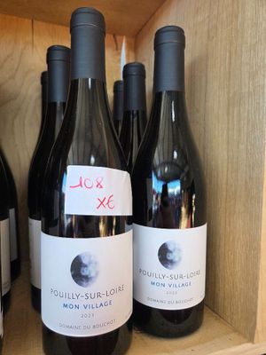 Plusieurs bouteilles de vin sont posées sur une étagère dans un magasin de vins.