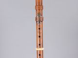 a flute with a wooden body and two holes in the middle