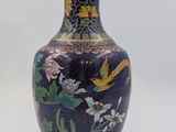 a blue vase with flowers and birds painted on it