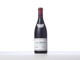 a bottle of red wine sitting on top of a white table