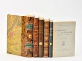 plusieurs livres sont empilés sur une surface blanche