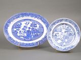 deux assiettes bleues et blanches ornées de motifs, posées sur un présentoir