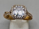 a close up of a diamond ring on a white surface
