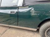 a green car that is parked on the side of the road