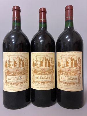 three bottles of red wine sitting on top of a white table