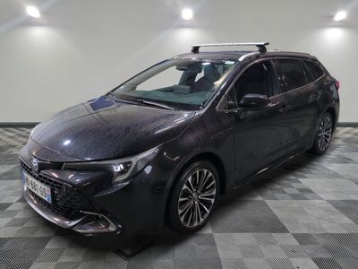 La Toyota Corollant est garée dans un garage dont le sol est en damier.