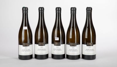 six bottles of wine are lined up on a white surface