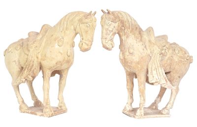 deux statues de chevaux placées côte à côte sur une surface blanche