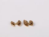 a pair of gold earrings on a white surface