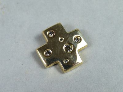 un morceau de métal doré sur lequel est gravée une croix