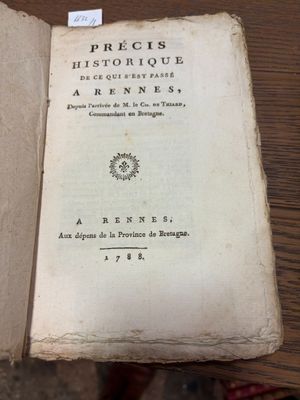un livre ouvert sur une table, sur lequel est collé un autocollant