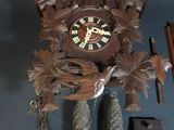 a cuckoo clock hanging on the wall with a bird on it
