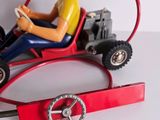 a figurine of a man driving a toy car with a steering wheel