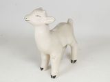 a small toy sheep that is standing on a white surface