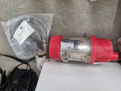 une photo d'un moteur rouge et argenté posé sur une table blanche