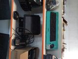 a desk with a keyboard, monitor, mouse, and other electronics on it