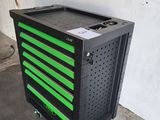 a black and green tool cabinet sitting on top of a cement floor