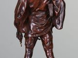 bronze statue of a man with a hat and a backpack