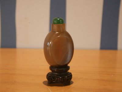 une petite bouteille en verre posée sur une table en bois