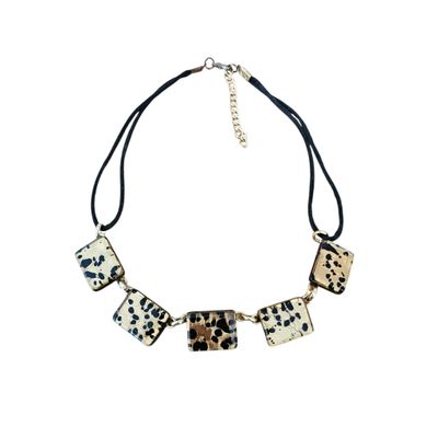 a black and white leopard print necklace on a black cord