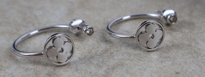 deux bagues en argent ornées d'une fleur, posées sur une table
