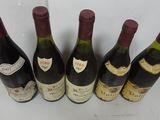 six bottles of wine are lined up in a row on a table