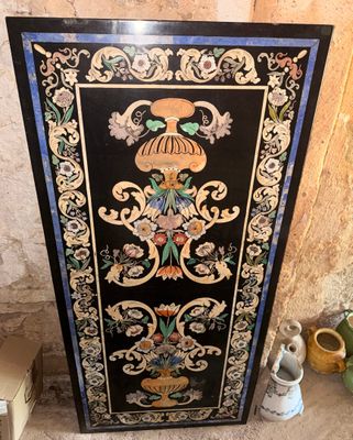 une image représentant une armoire peinte en noir et or, sur laquelle figure un oiseau
