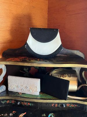 a black and white hat sitting on top of a wooden shelf