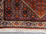 an oriental rug with a red, blue, and orange design