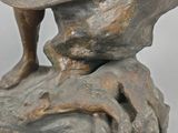 bronze statue of a boy on a rock with a bird on his shoulder