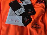 une chemise orange avec deux étiquettes, posée sur une chaise