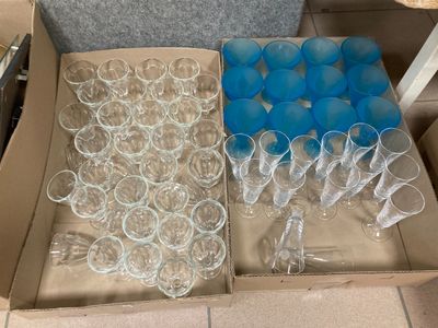 une boîte de verres à vin vides posée par terre