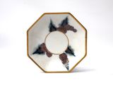 a white and gold plate with a bird design on it
