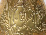a gold vase with a design on it on a table