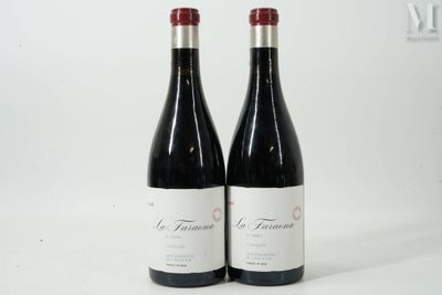 two bottles of red wine sitting next to each other on a white surface