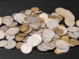 une pile de pièces d'argent et d'or sur une surface noire