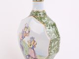 a green and white vase with a painting on it